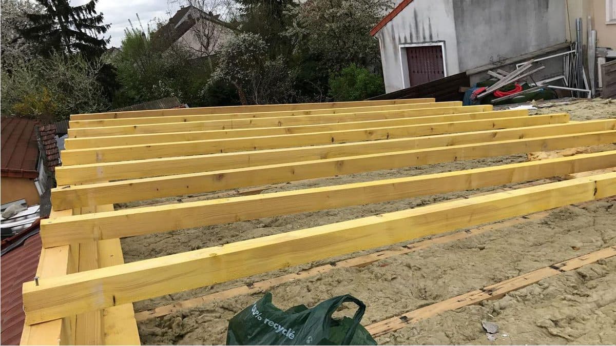 Chevrons en bois neufs posés au-dessus d'une couche d'isolant en laine minérale, lors d'une isolation de toiture par l'extérieur